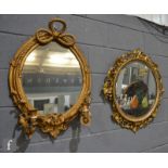 A 19th Century gilt and gesso twin branch girandole wall mirror, with tied ribbon pediment, together