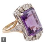 An 18ct hallmarked amethyst and diamond ring, central emerald cut amethyst set with five diamonds to