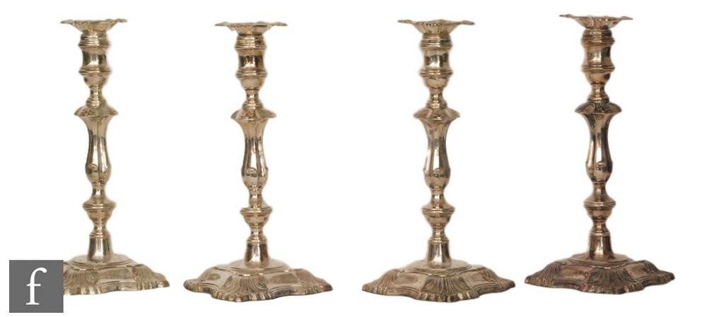 A set of four Victorian hallmarked candlesticks, a each with scalloped square base with shell