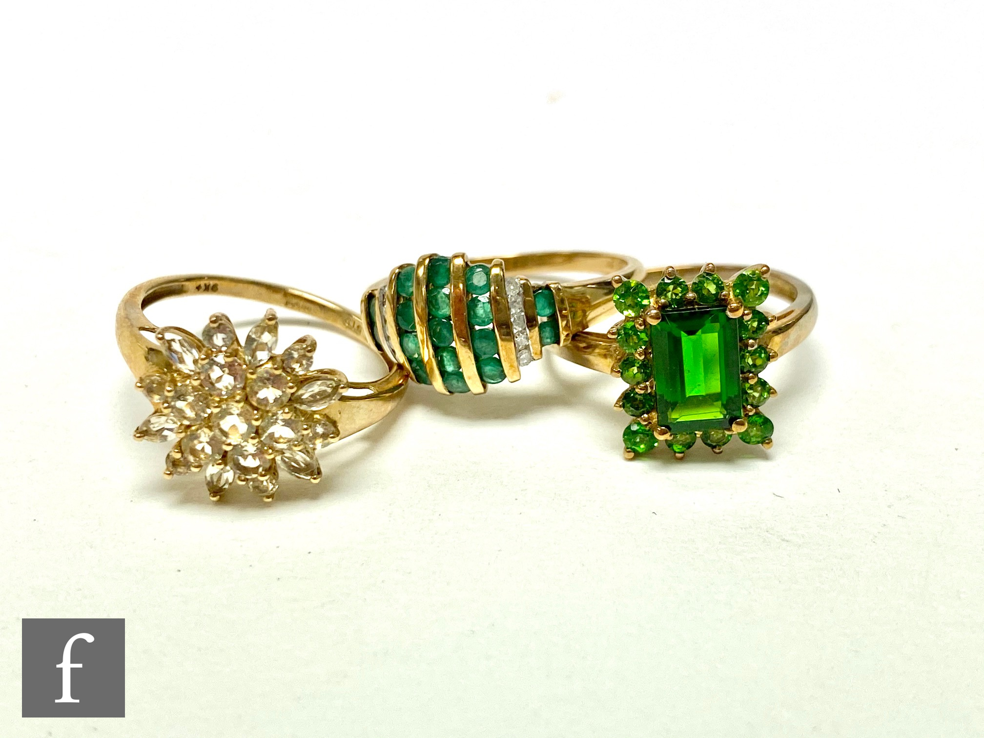 Three 9ct hallmarked stone set rings, an emerald and diamond, a diopside and a paste example,