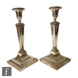 A pair of Victorian silver hallmarked candlesticks, the stepped square base rising to a tapered stem