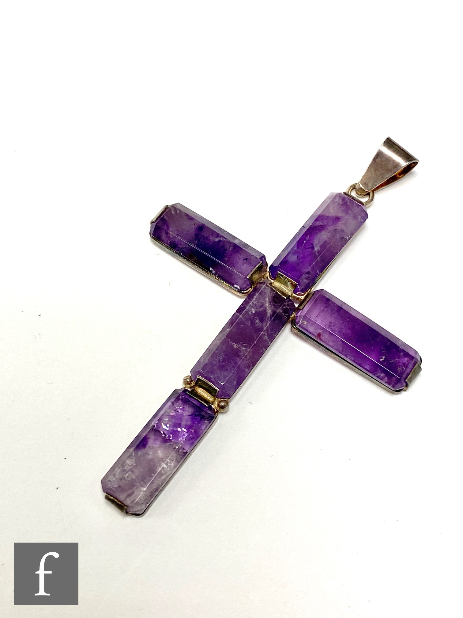 A 1970's decorative pendant in the form of a cross with a silver frame set with rectangular panels
