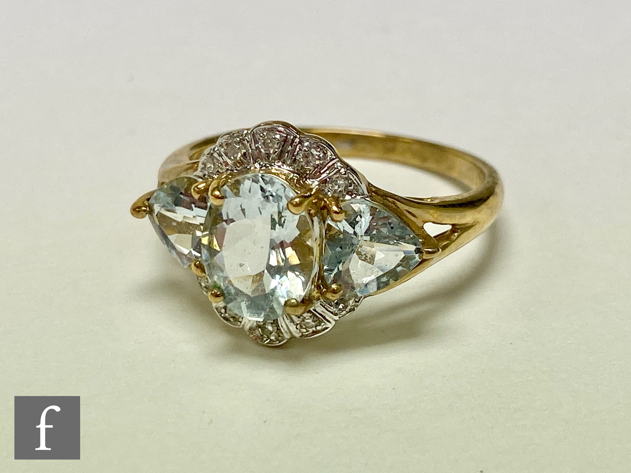 A 9ct aquamarine and diamond cluster ring, central oval aquamarine flanked by two further heart