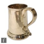 A late 18th Century hallmarked silver pint tankard of plain form terminating in scroll handle