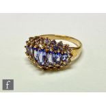 A 9ct hallmarked tanzanite cluster ring, seven graduated marquise cut stones within a double row