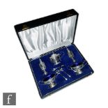 An Edwardian cased silver hallmarked condiment set, to include two salts with blue glass liners, two