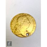 A George III guinea 1763, holed.