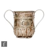 A George III hallmarked silver twin handled cup with part fluted decoration and reeded details to