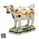 An early 19th Century pearlware cow creamer and cover, she decorated with tan wavy lines and black