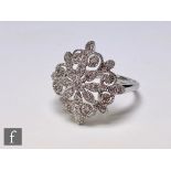 A 9ct hallmarked white gold diamond cluster ring modelled as a snowflake, width of head 20mm, weight