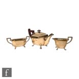 An Art Deco hallmarked silver three piece tea set of faceted boat shaped form raised on four paw