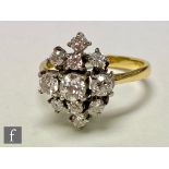 An 18ct hallmarked diamond cluster ring comprising eleven individually claw set transitional cut