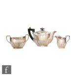A hallmarked silver three piece boat shaped tea set with part fluted decoration, total weight