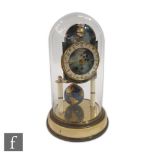 A 20th Century 365 day moon face mantle clock in glass dome with sphere pendulum on painted