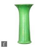 A large Ruskin Pottery trumpet vase decorated in an all over apple green lustre, impressed mark,