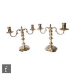 A pair of contemporary cast silver two-branch candelabra with candlesticks of octagonal form, with