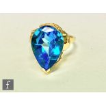 An 18ct hallmarked single stone blue topaz ring, pear shaped claw set stone to stepped shoulders,