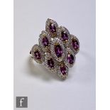 A 9ct rhodolite and diamond cluster ring comprising nine marquise cut rhodolites each within a