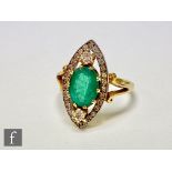 An 18ct hallmarked emerald and diamond ring, central oval emerald within a diamond set above and