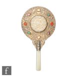 A late Qing Dynasty (1644-1912) Chinese lady's white metal hand mirror, with carved inset jade