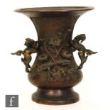 A Chinese Bronze vase of footed bauster form, decorated with flowering boughs and Qilin over a panel