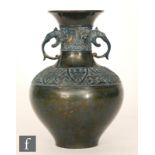 A Japanese bronze vase of footed baluster form with collar neck and applied lion mask handles,