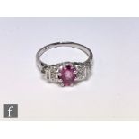 A platinum ruby and diamond cluster ring, central claw set ruby flanked by two brilliant cut and one