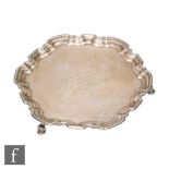 A hallmarked silver circular salver, the central presentation engraving with pie crust border, all