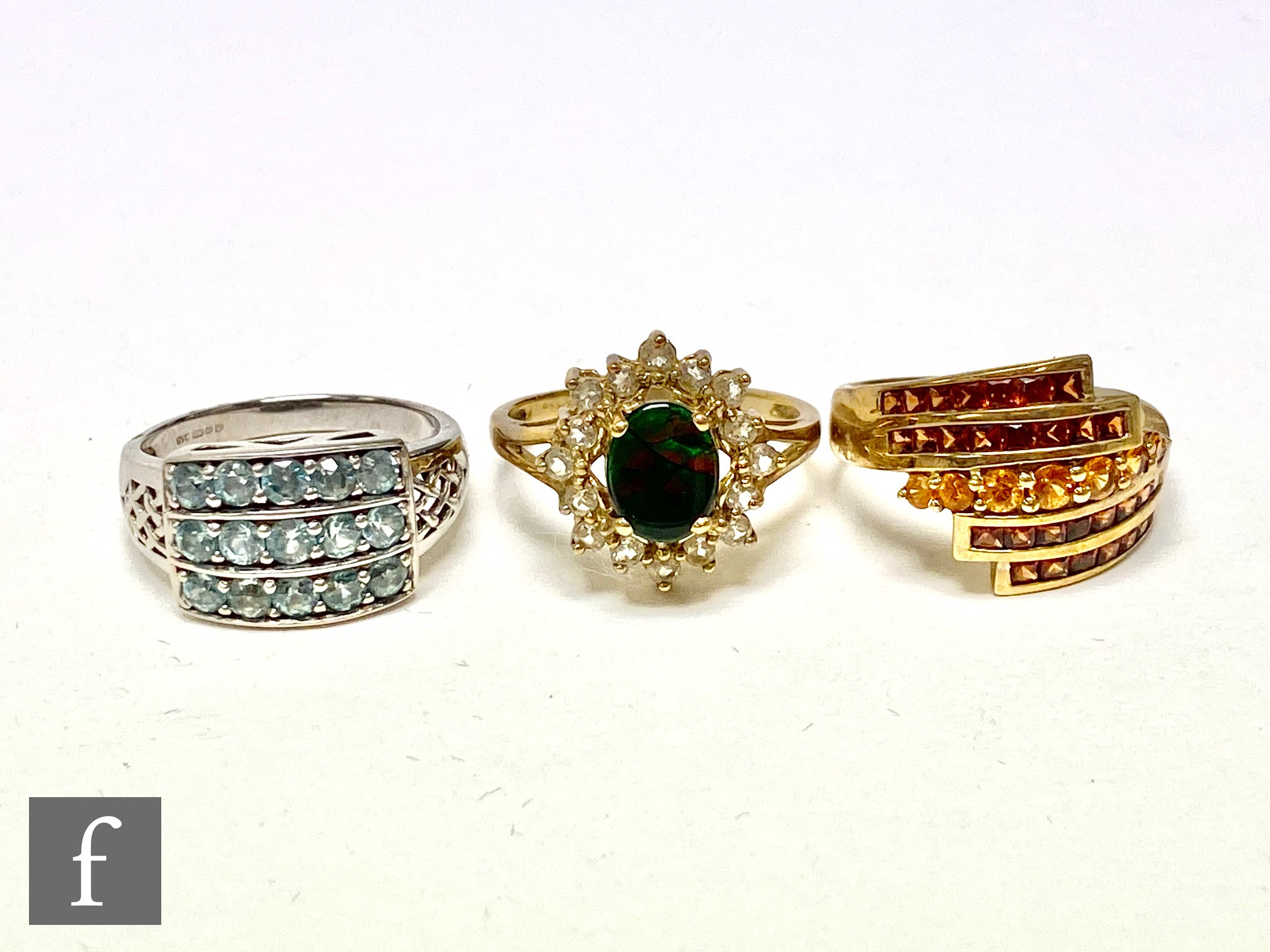 Three 9ct hallmarked stone set rings; a two coloured garnet, a blue zircon and a ammolite doublet