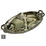 A WMF pewter oval dressing table tray decorated with a young child looking at a snail, impressed