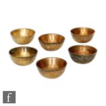A set of six early 20th Century Chinese brass offering/rice bowls, each of rounded form, incised