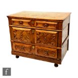 An 18th Century pine and elm chest of three geometric panel fronted long drawers, raised to later