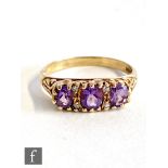 A 9ct hallmarked amethyst three stone ring, stones spaced by two pairs of diamonds, weight 2.7g,