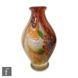 A contemporary studio glass vase of footed ovoid form internally decorated with multicoloured swirls