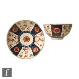 An 18th Century teabowl and saucer with Kakiemon type decoration with stylised flowers in orange