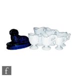 A late 19th Century pressed glass figure of a recumbent hound on a fluted oval base all in deep