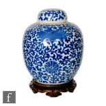 A Chinese 19th Century blue and white jar and cover of rounded form, the large flowerheads borne