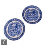 A pair of 19th century Chinoiserie shallow dish plates, each decorated with a blue and white