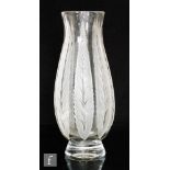 A 1930s French glass vase of footed swollen sleeve form, deeply cut with vertical stylised leaves,