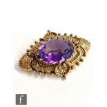 A modern 9ct hallmarked brooch, single stone amethyst within a Victorian style foliate border,