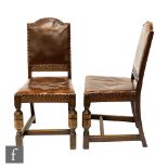 A set of four 1930s oak leather and brass studded dining chairs on turned legs and H-form