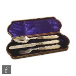 A cased hallmarked silver and mother of pearl knife, fork and spoon set with engraved decoration