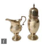 A hallmarked silver pedestal cream jug with a baluster sugar castor both of plain form, total weight