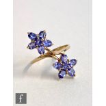A 9ct hallmarked tanzanite ring, claw set stones to double flower head all to a plain shank,
