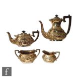 A hallmarked silver four piece boat shaped tea set with embossed foliate decoration and scroll