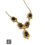 A 9ct hallmarked necklet set with five oval smoky quartz stones within foliate mounts and