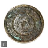 A Chinese Ming Dynasty (1368-1644) bronze mirror, the circular mirror cast with segmented borders,
