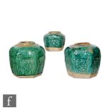 A collection of Chinese Shiwan style pottery jars, the green glazed incised panel sided vases with