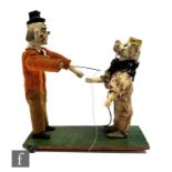 An early 20th Century penny toy of a clown and a circus dog, each with composition head and wooden