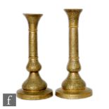 A matched pair of 19th Century Qajar brass candlesticks, Persia, the domed foot of each extending to